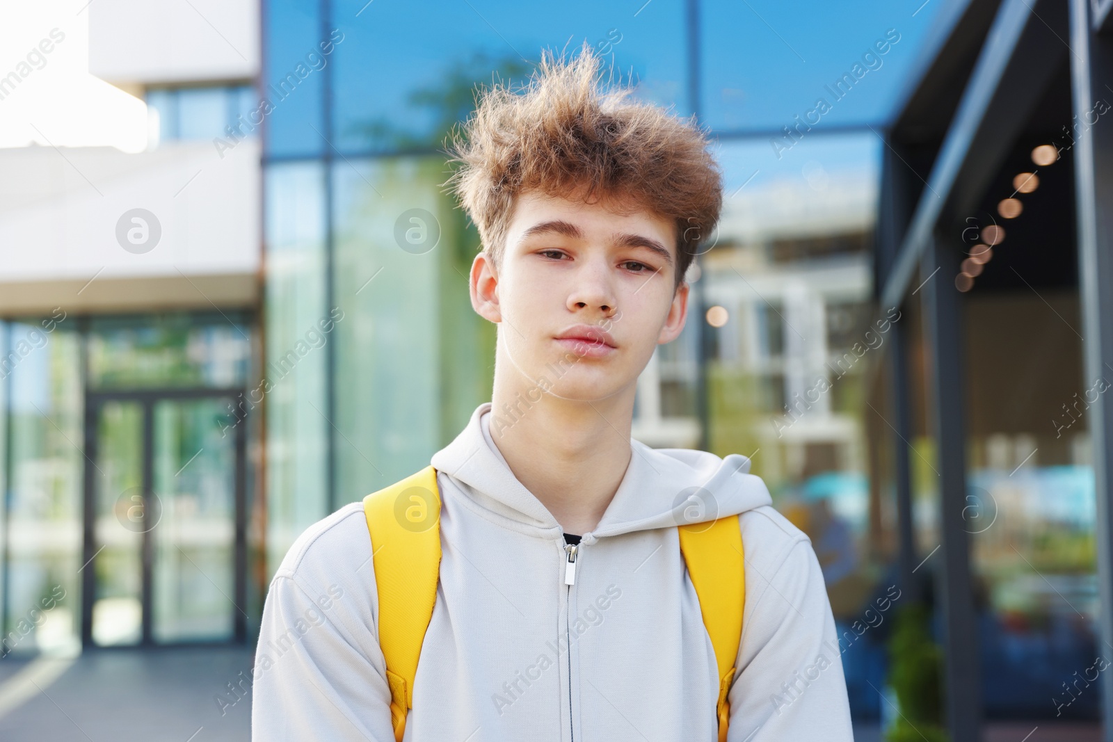 Teenage boy with backpack near building outdoors Photo of Teenage boy with backpack near building outdoors