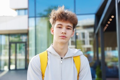 Photo of Teenage boy with backpack near building outdoors