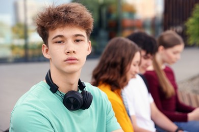 Photo of Teenagers spending time together outdoors, selective focus