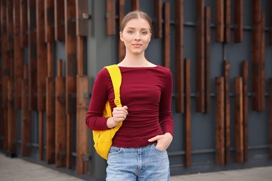 Photo of Teenage girl with backpack near building outdoors
