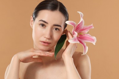 Photo of Portrait of beautiful woman after spa treatment with lily flower on beige background