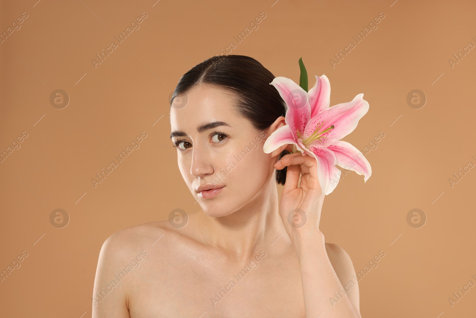 Portrait of beautiful woman after spa treatment with lily flower on beige background Photo of Portrait of beautiful woman after spa treatment with lily flower on beige background