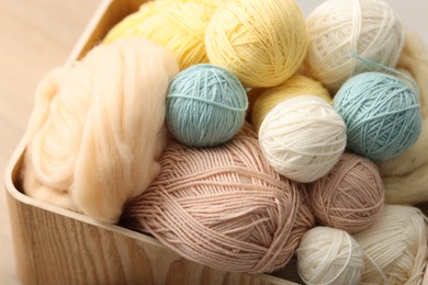 Photo of Felting wool and knitting yarn in wooden basket, closeup