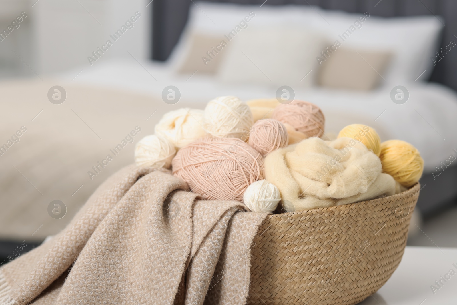 Felting wool and knitting yarn in wicker basket indoors, closeup Photo of Felting wool and knitting yarn in wicker basket indoors, closeup