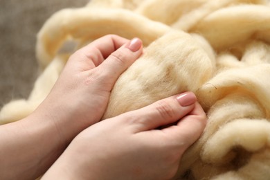 Photo of Woman with beige soft felting wool, closeup