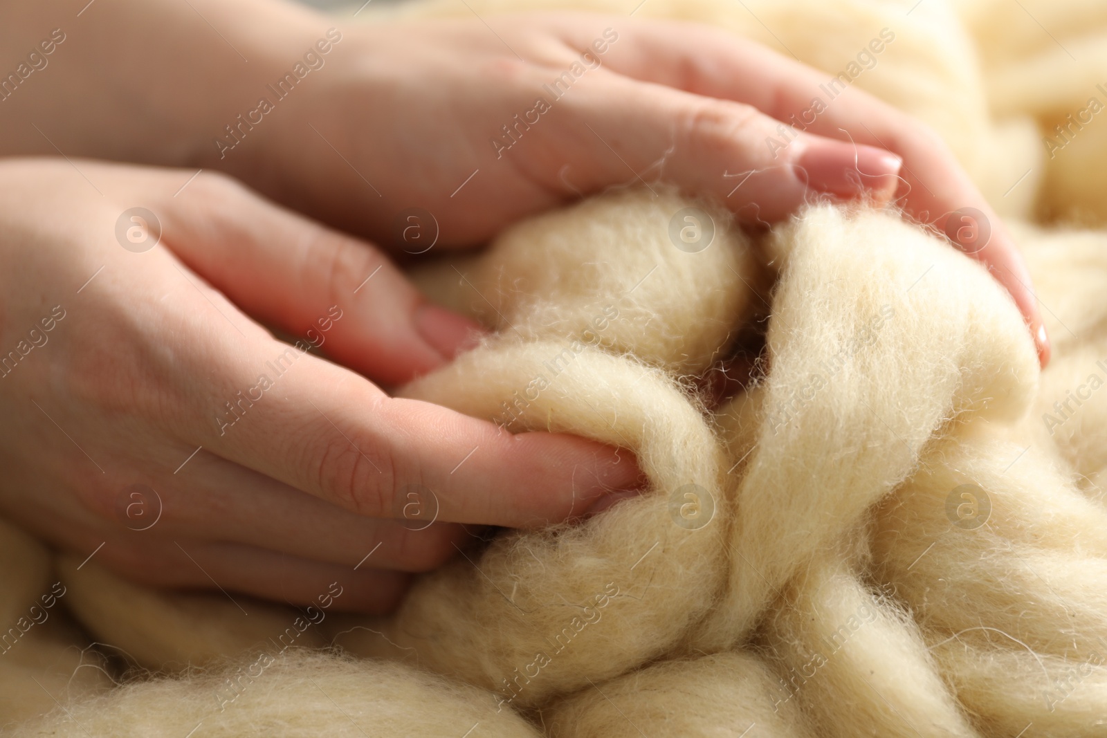 Photo of Woman with beige soft felting wool, closeup