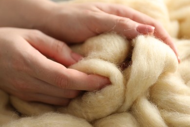 Photo of Woman with beige soft felting wool, closeup