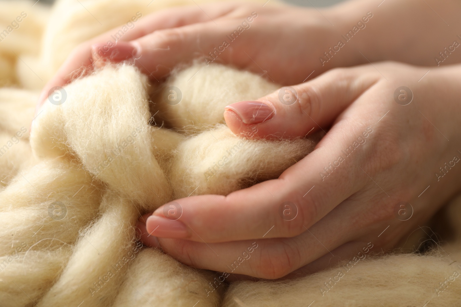 Photo of Woman with beige soft felting wool, closeup