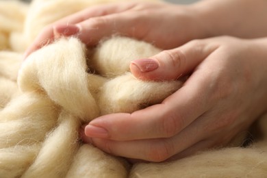 Photo of Woman with beige soft felting wool, closeup