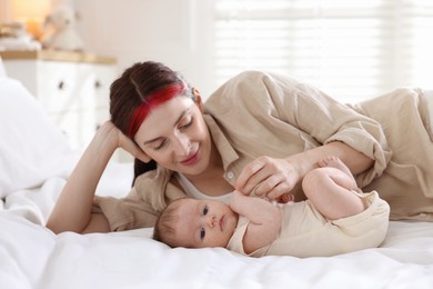 Photo of Mother with her newborn baby on bed indoors