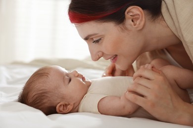 Photo of Mother with her newborn baby on bed indoors