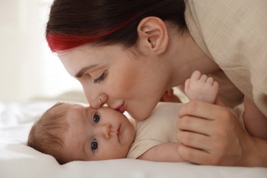 Photo of Mother with her newborn baby on bed indoors