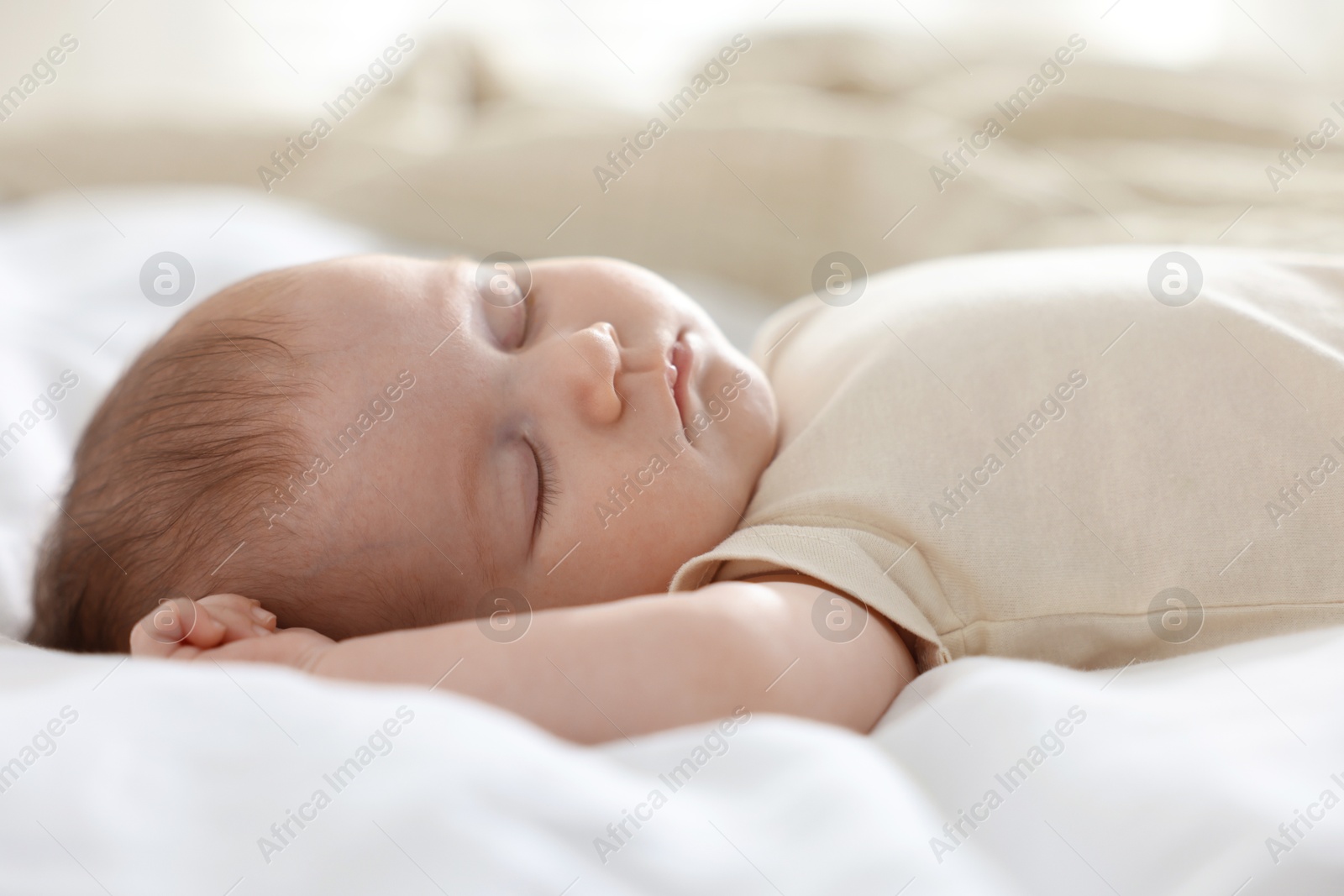 Cute newborn baby sleeping on bed indoors Photo of Cute newborn baby sleeping on bed indoors