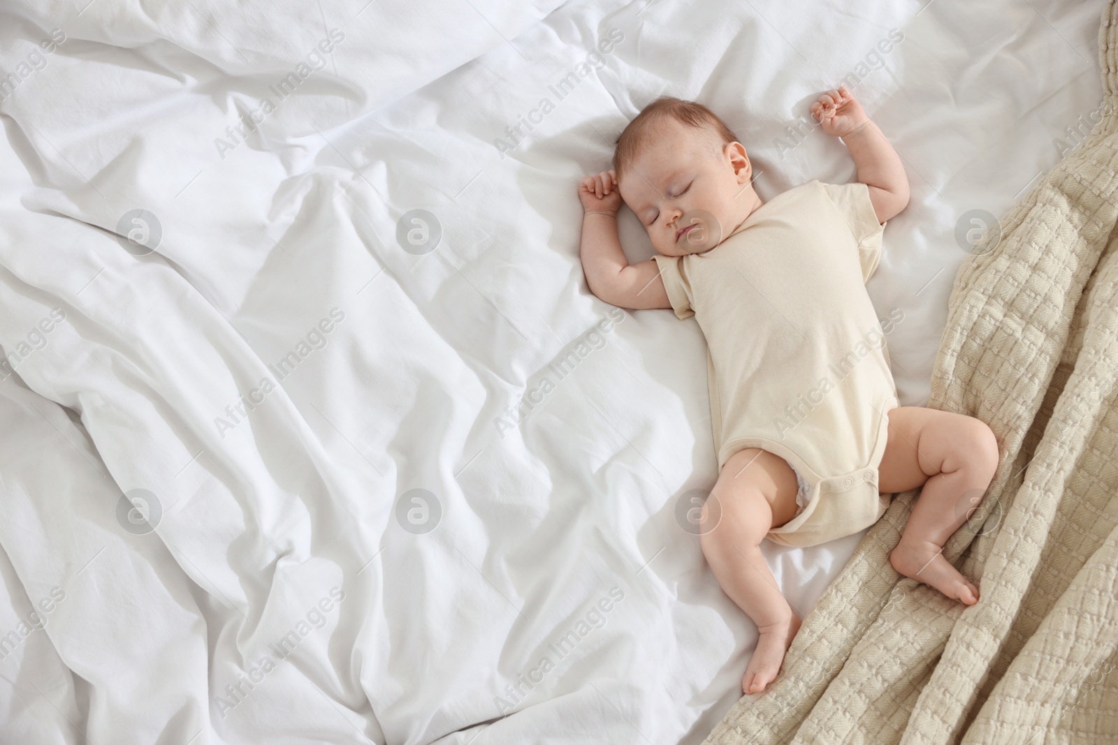 Cute newborn baby sleeping on bed indoors, top view. Space for text Photo of Cute newborn baby sleeping on bed indoors, top view. Space for text