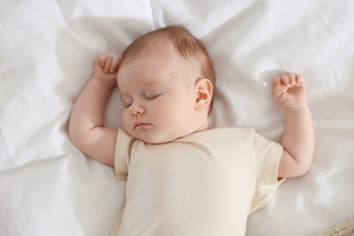 Photo of Cute newborn baby sleeping on bed indoors, top view