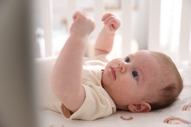 Photo of Cute newborn baby lying in crib, closeup