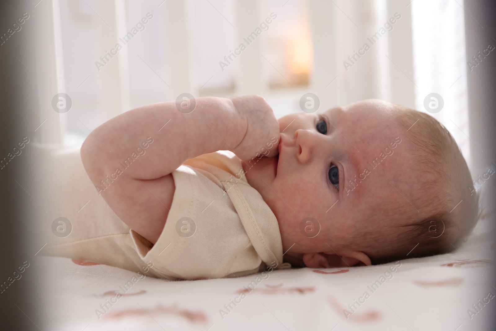 Cute newborn baby lying in crib, closeup Photo of Cute newborn baby lying in crib, closeup