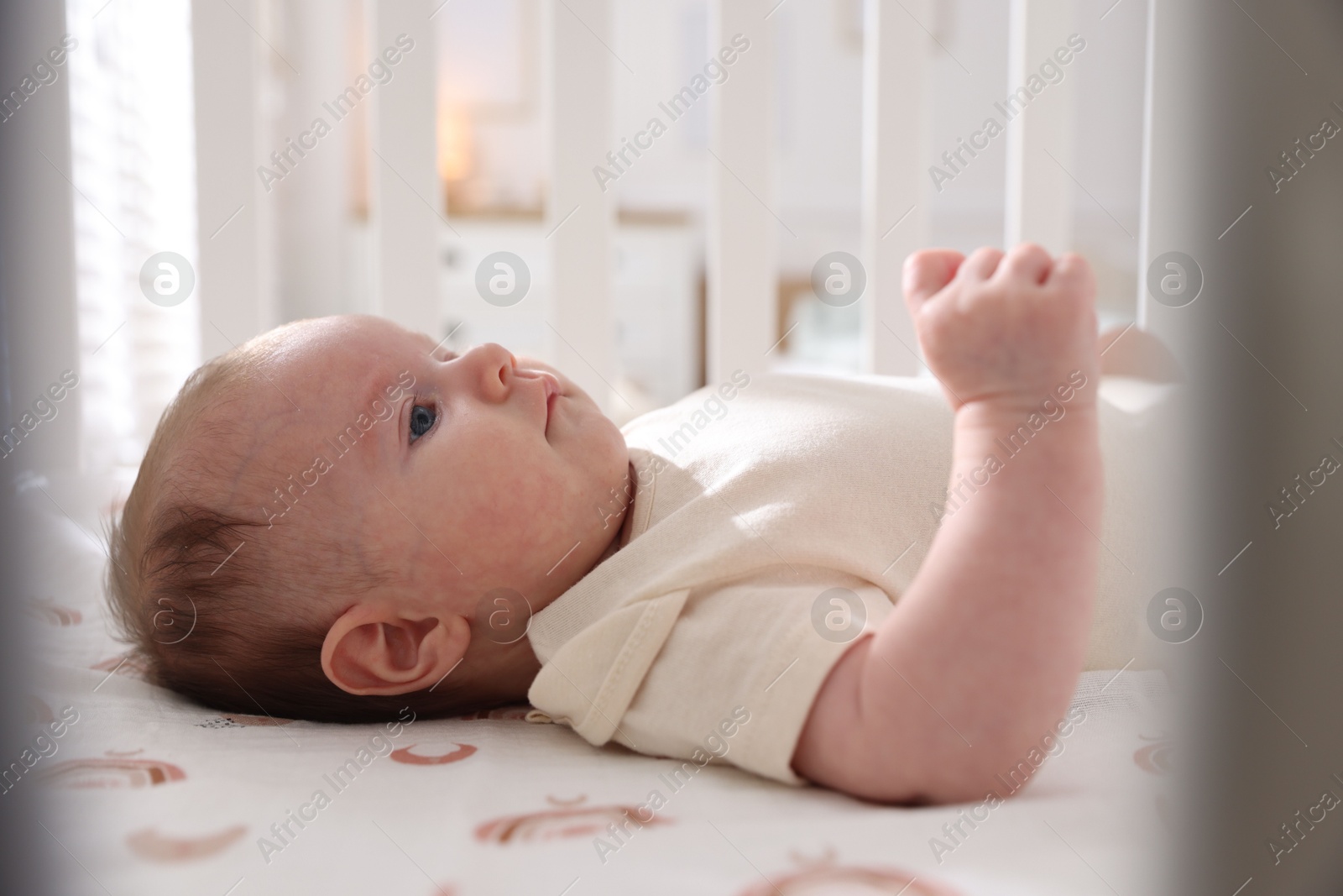 Cute newborn baby lying in crib, closeup Photo of Cute newborn baby lying in crib, closeup