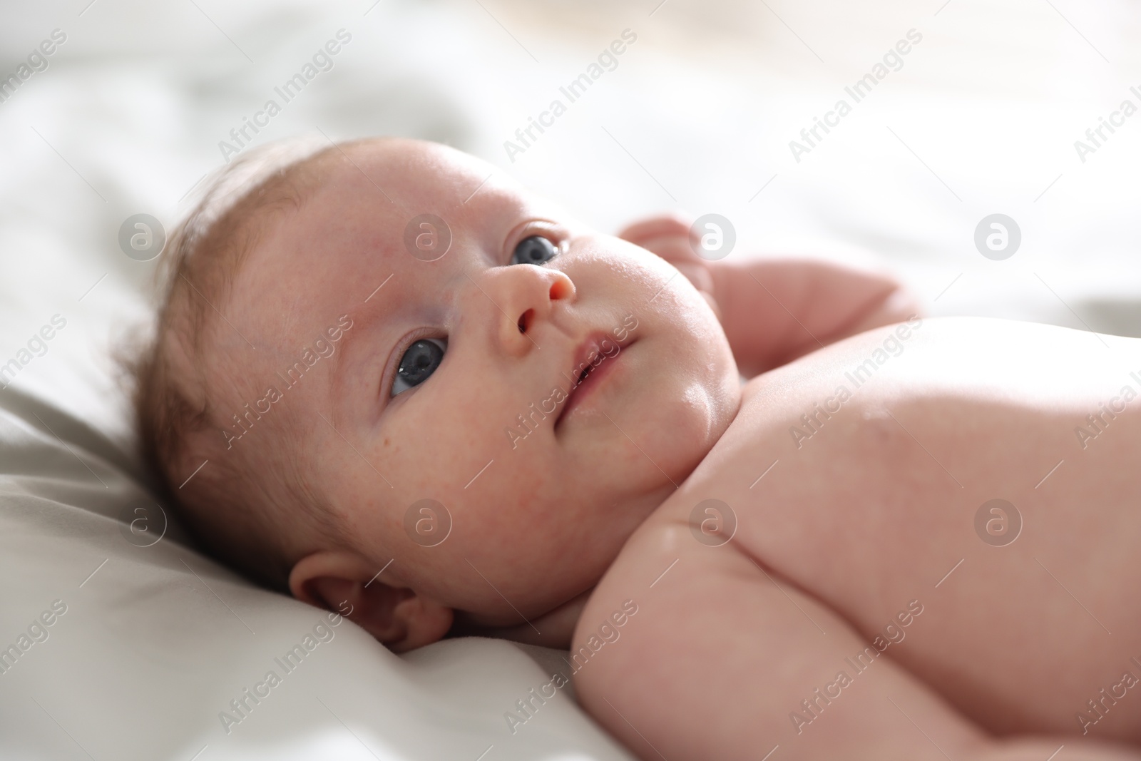 Cute newborn baby lying on bed, closeup Photo of Cute newborn baby lying on bed, closeup