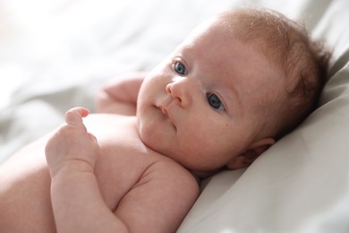 Photo of Cute newborn baby lying on bed, closeup