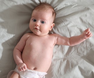 Photo of Cute newborn baby lying on bed, top view