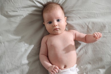 Photo of Cute newborn baby lying on bed, top view