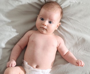 Photo of Cute newborn baby lying on bed, top view