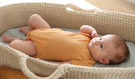 Photo of Cute newborn baby in bassinet at home