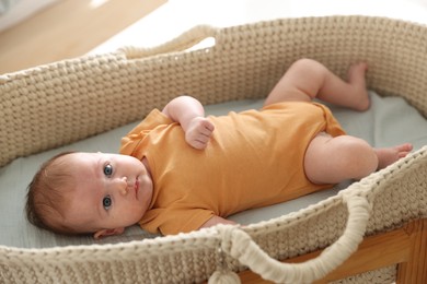 Photo of Cute newborn baby in bassinet at home