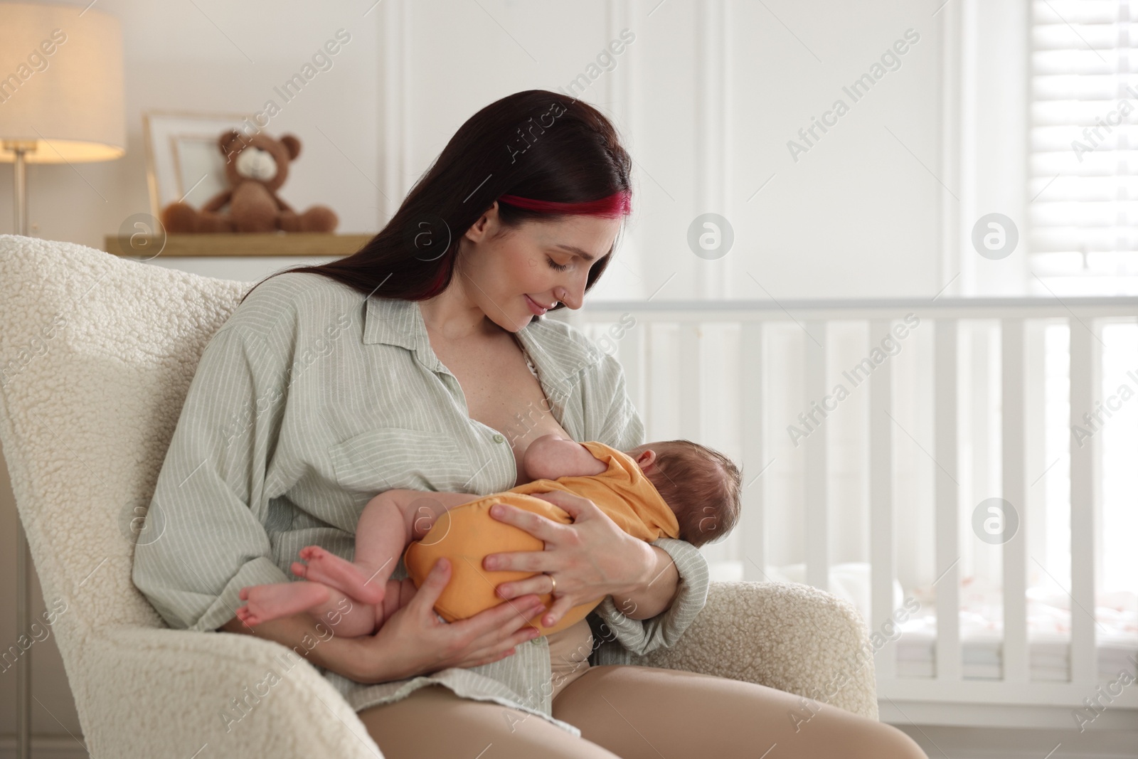 Mother breastfeeding her newborn baby at home. Space for text Photo of Mother breastfeeding her newborn baby at home. Space for text