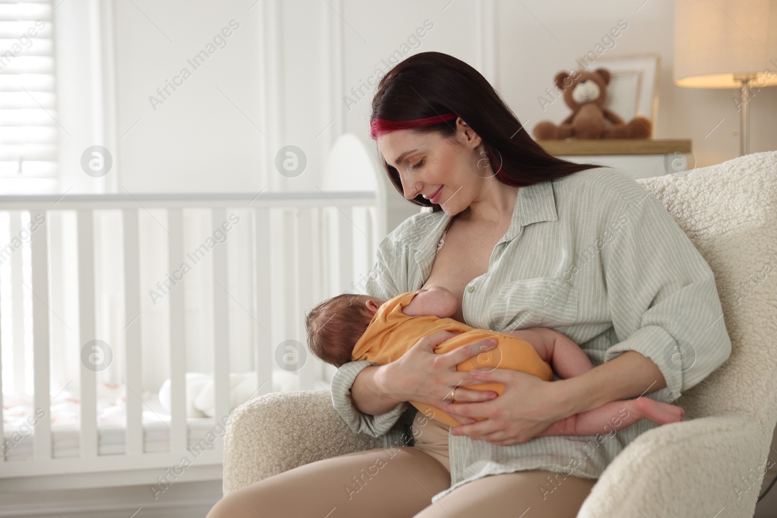 Mother breastfeeding her newborn baby at home. Space for text Photo of Mother breastfeeding her newborn baby at home. Space for text