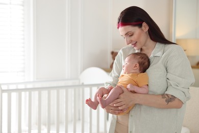 Photo of Mother with her cute newborn baby at home. Space for text