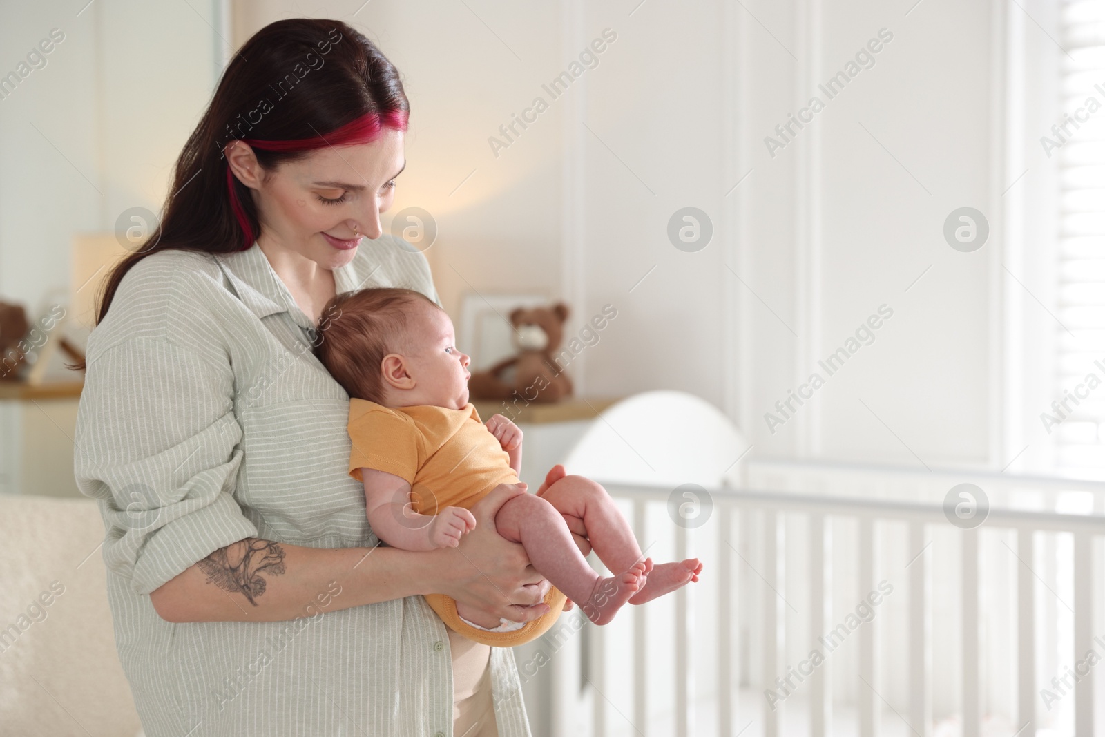 Mother with her cute newborn baby at home. Space for text Photo of Mother with her cute newborn baby at home. Space for text