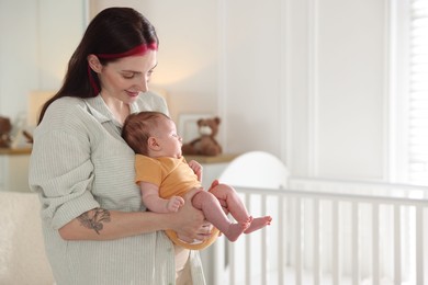 Photo of Mother with her cute newborn baby at home. Space for text