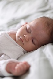 Photo of Cute newborn baby sleeping on bed, closeup