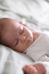 Photo of Cute newborn baby sleeping on bed, closeup