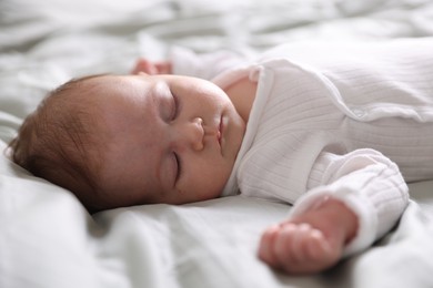 Photo of Cute newborn baby sleeping on bed, closeup