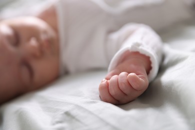 Photo of Cute newborn baby sleeping on bed, selective focus