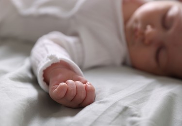 Photo of Cute newborn baby sleeping on bed, selective focus