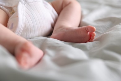 Photo of Cute newborn baby lying on bed, closeup