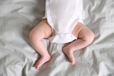 Photo of Cute newborn baby lying on bed, top view
