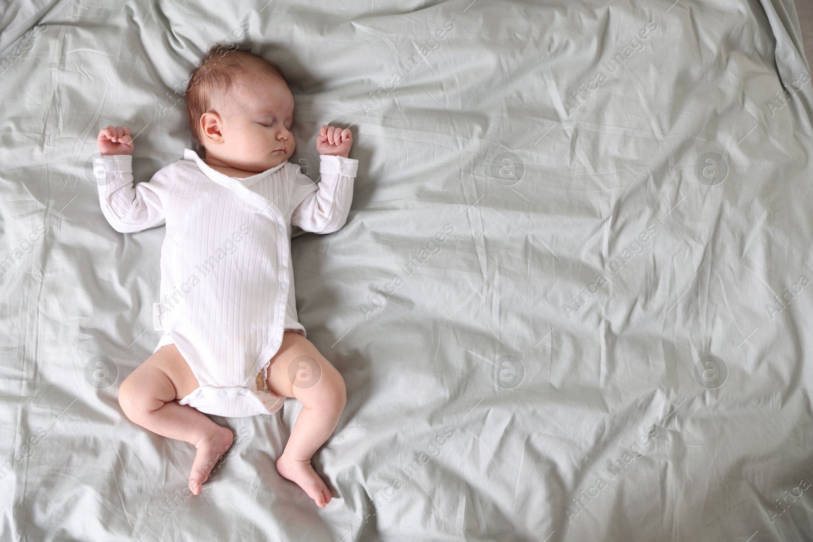 Cute newborn baby sleeping on bed, top view. Space for text Photo of Cute newborn baby sleeping on bed, top view. Space for text