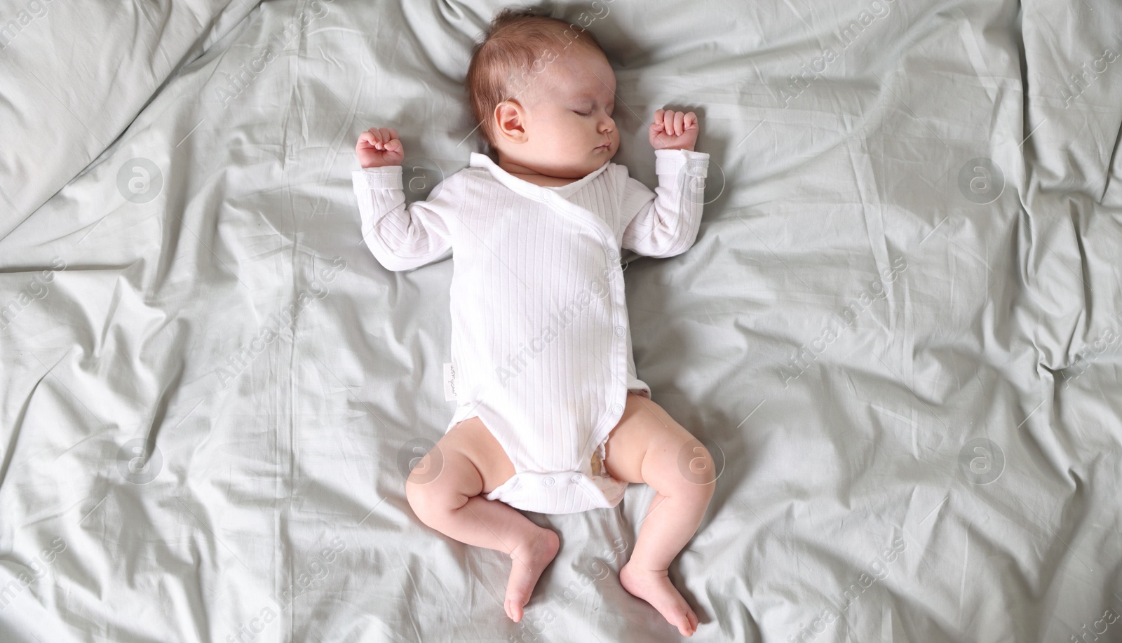 Cute newborn baby sleeping on bed, top view Photo of Cute newborn baby sleeping on bed, top view