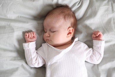 Photo of Cute newborn baby sleeping on bed, top view