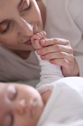 Photo of Mother kissing her baby's hand indoors, closeup