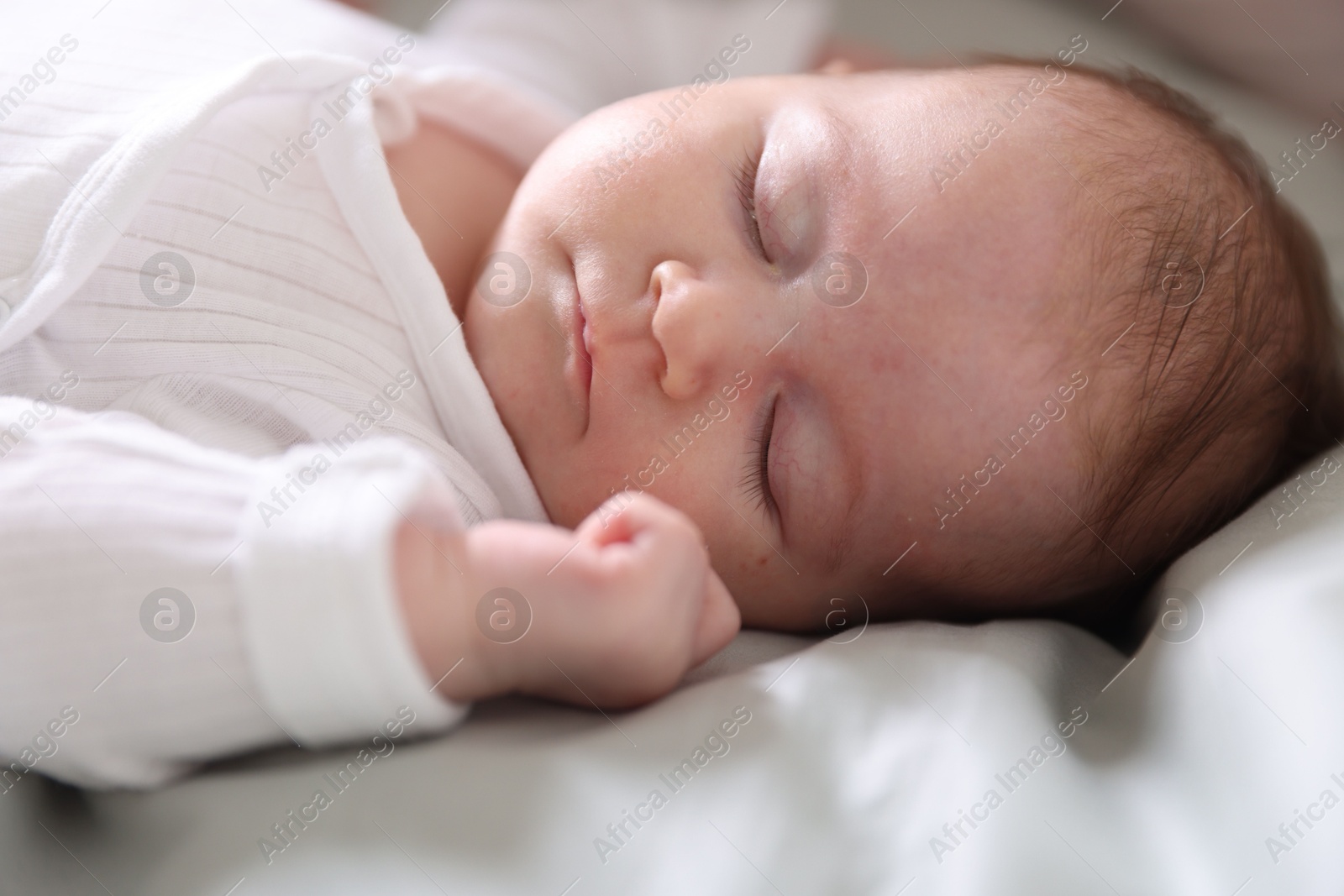 Cute newborn baby sleeping on bed, closeup Photo of Cute newborn baby sleeping on bed, closeup