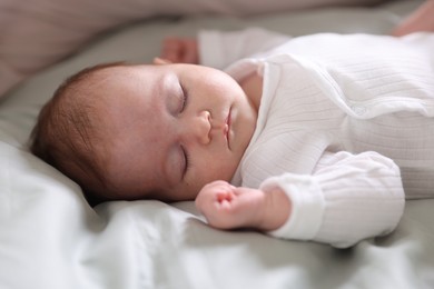 Photo of Cute newborn baby sleeping on bed, closeup