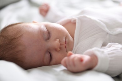 Photo of Cute newborn baby sleeping on bed, closeup