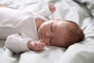 Photo of Cute newborn baby sleeping on bed, closeup