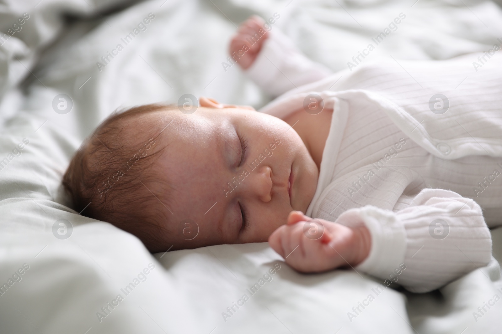 Cute newborn baby sleeping on bed, closeup Photo of Cute newborn baby sleeping on bed, closeup